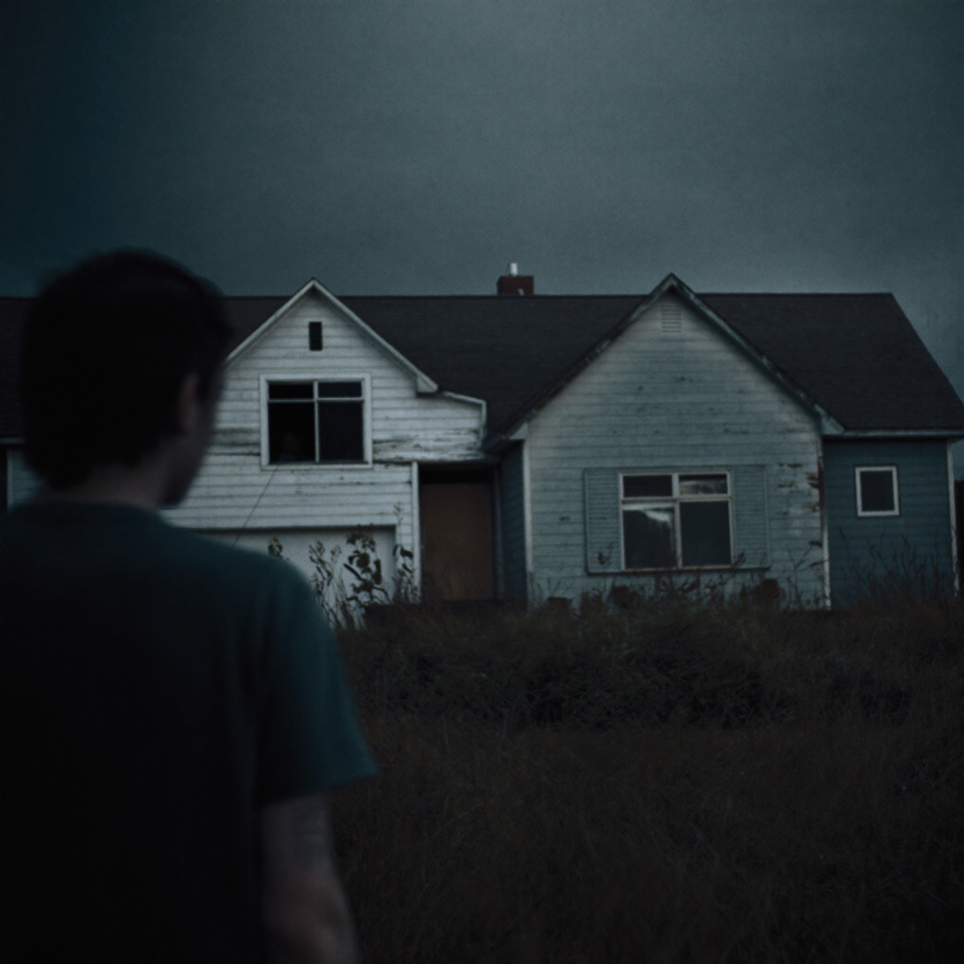 A weathered two-storey house at dusk